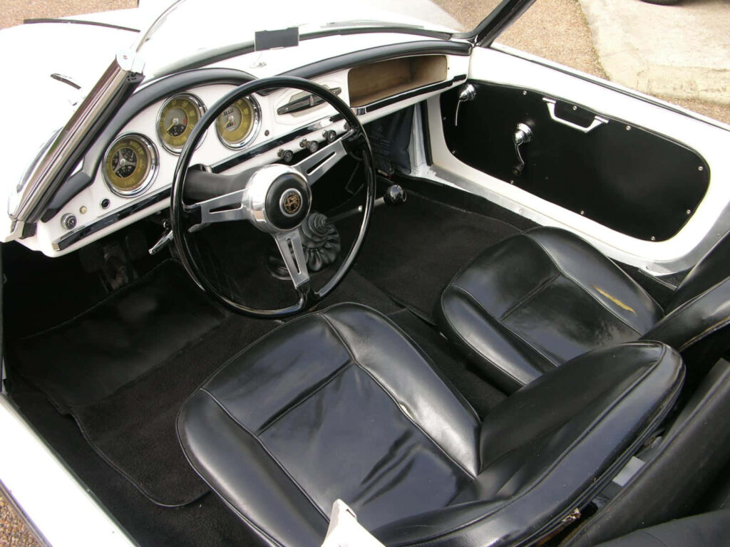 Classic Alfa Romeo Spider interior with black leather seats and vintage dashboard wallpaper