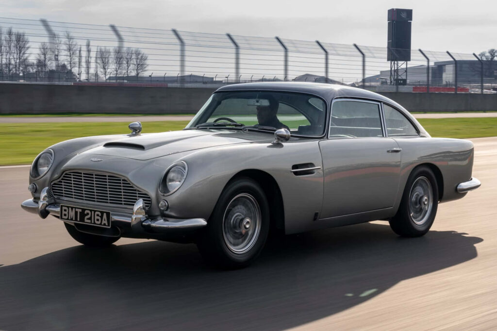 Classic Aston Martin DB5 silver sports car gliding smoothly on track showcasing timeless design Wallpaper