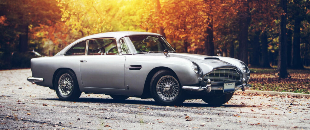 Classic Aston Martin DB5 Autumn Wallpaper: Timeless Elegance in Gold