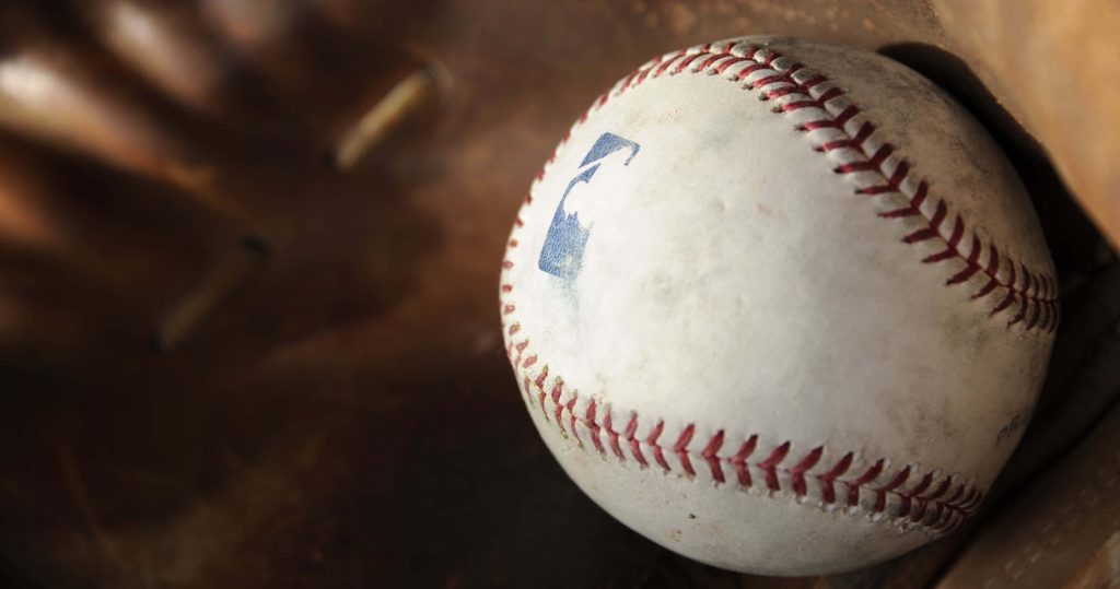 High-resolution close-up of an official MLB baseball in a textured brown leather glove background Wallpaper