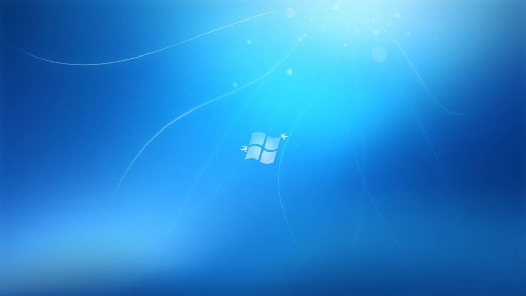 Classic Windows 7 blue wallpaper with iconic logo and vibrant light-infused gradient background