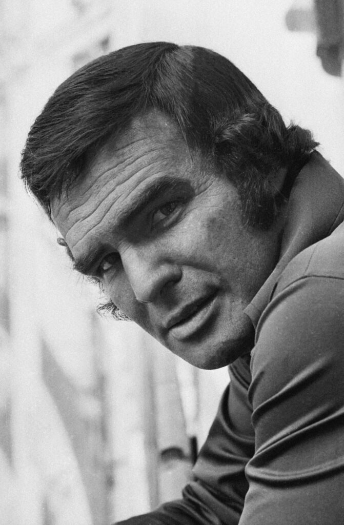 Black and white portrait of Burt Reynolds with iconic hairstyle and rugged charm wallpaper background