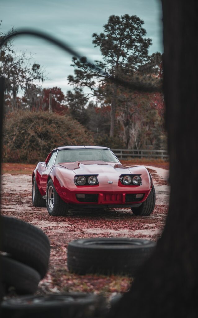 Classic Red Chevrolet Corvette Wallpaper: Sleek Front View Outdoors