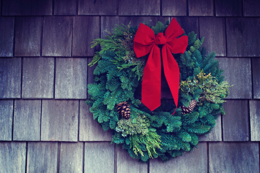 Festive Christmas Wreath Wallpaper with Red Bow on Rustic Wood