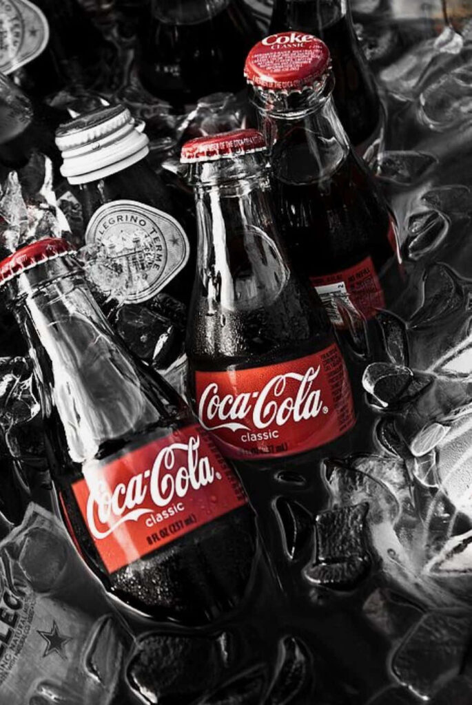 Coca-Cola glass bottles in ice with red labels vintage wallpaper high resolution chilled texture