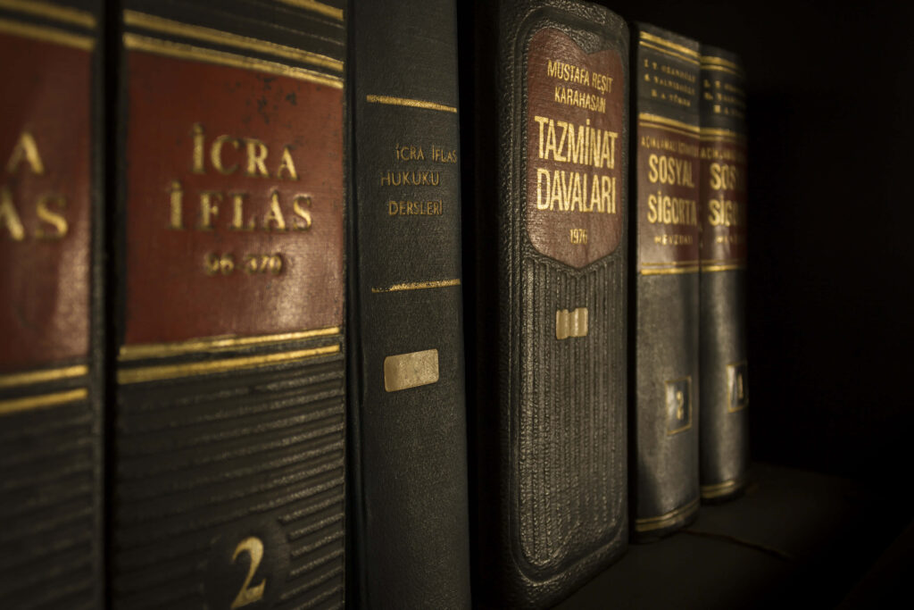 Close-up of classic law books with gold titles on dark leather spines neatly arranged on shelf Wallpaper