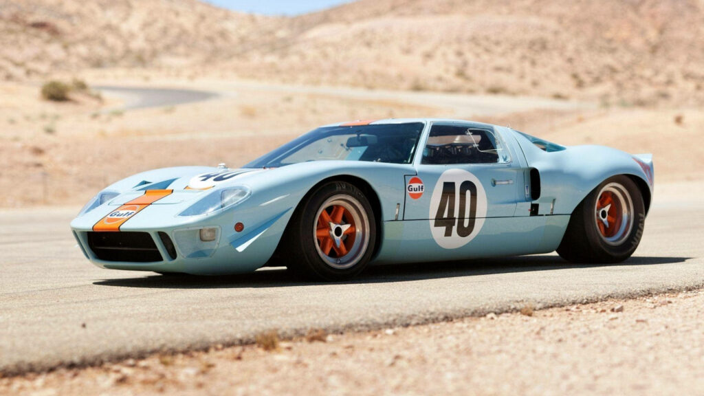 Classic light blue Ford GT40 with Gulf livery parked on desert racetrack vintage racing car Wallpaper