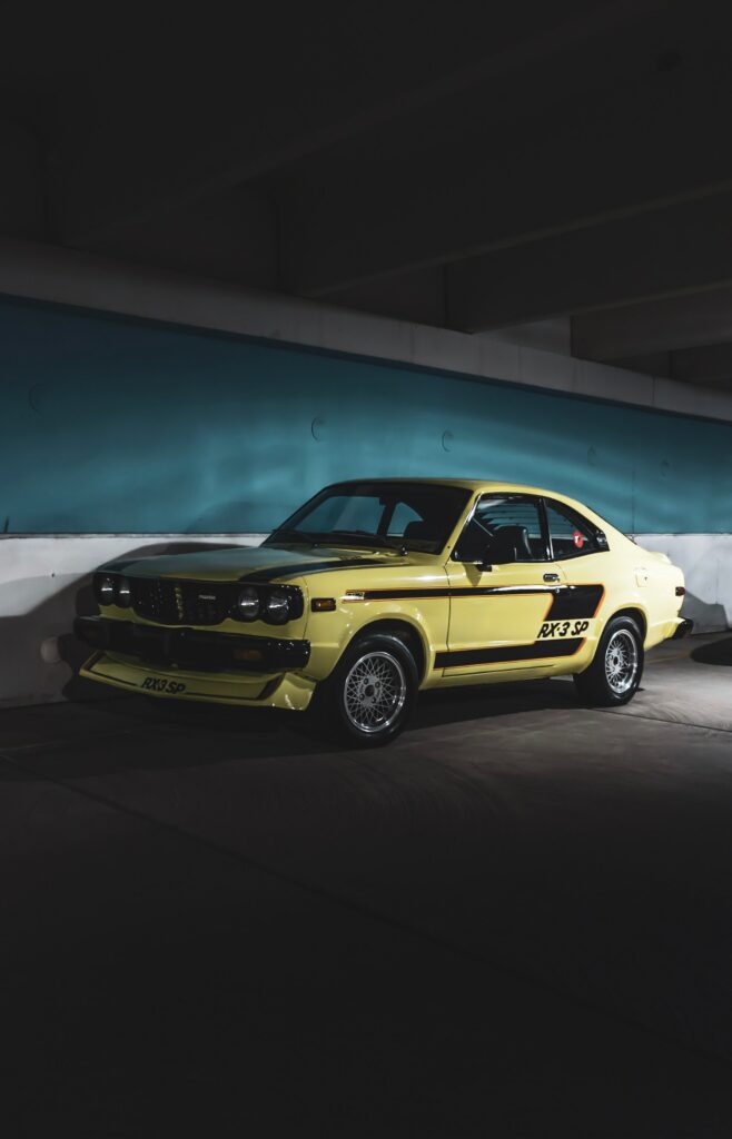 Classic Mazda in Dim Garage: A Side View of Muscle Car Icon Wallpaper