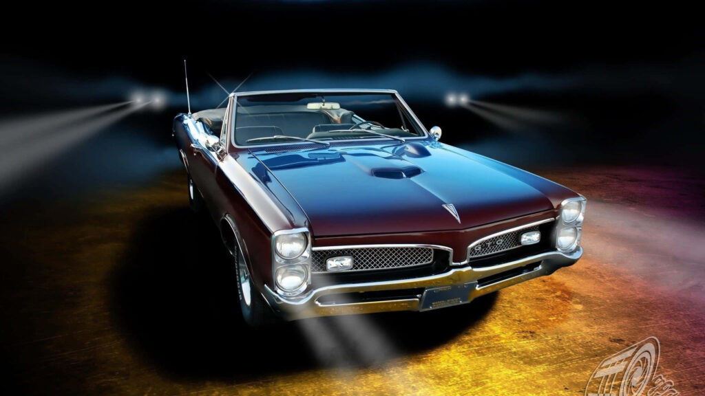 Classic Pontiac GTO vintage car with polished finish showcased under dramatic lighting wallpaper