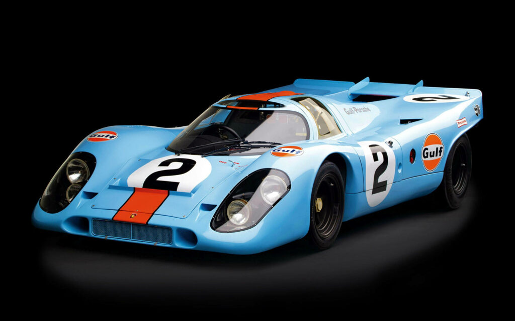 Classic Porsche race car with retro Gulf blue orange livery on sleek black background wallpaper