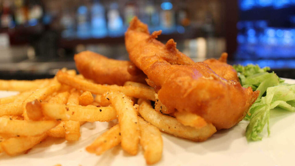 Cozy Pub Wallpaper: Classic Fish and Chips with Greens Close-Up