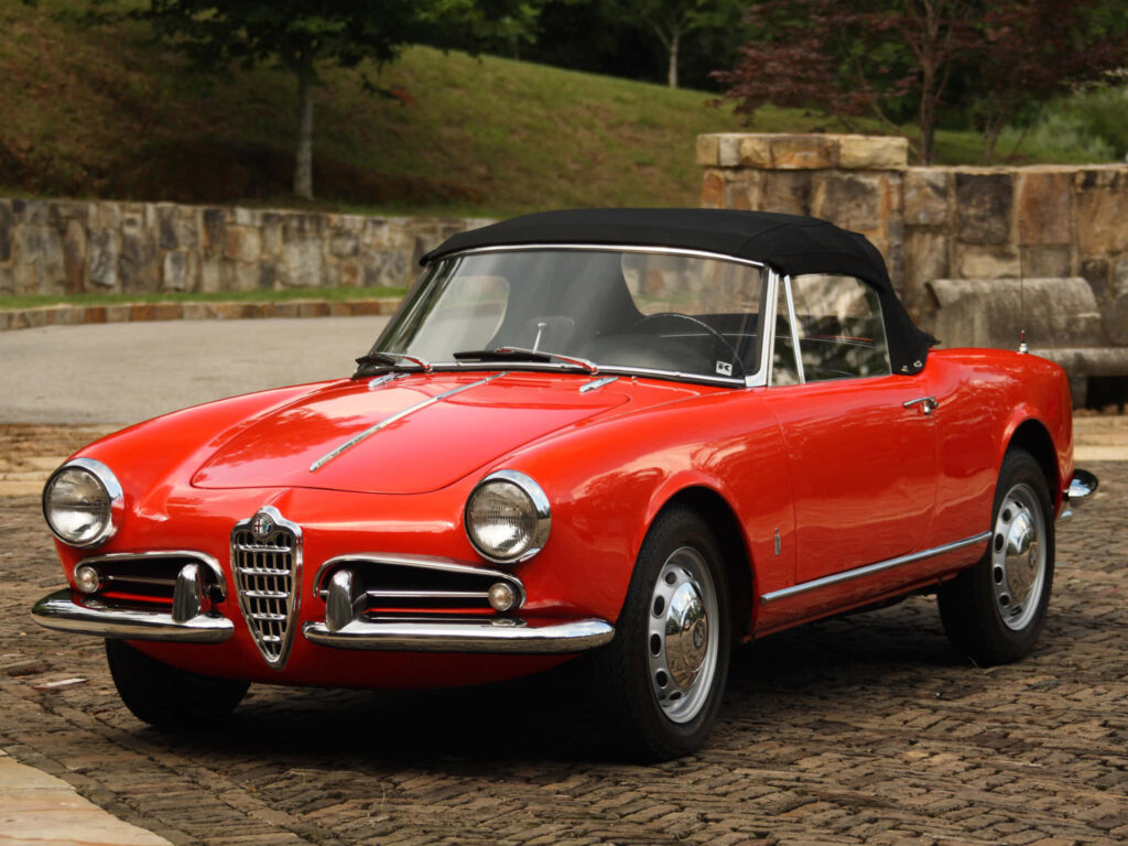 Classic red Alfa Romeo Spider wallpaper with elegant Italian design in scenic outdoor setting