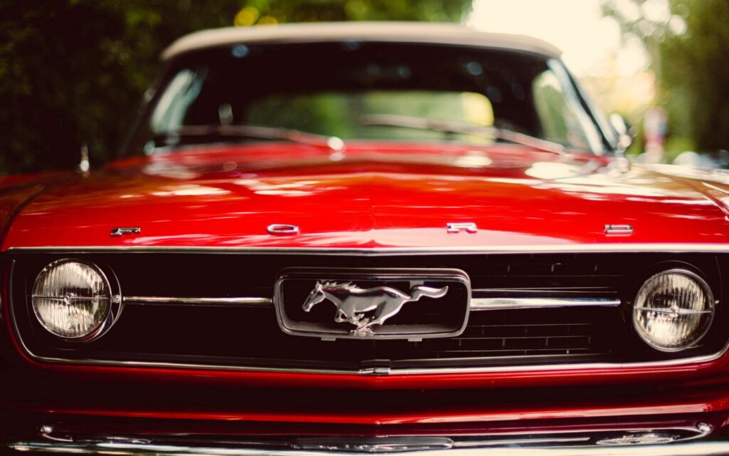 Classic Red Ford Mustang Wallpaper: Iconic Design on Green Background