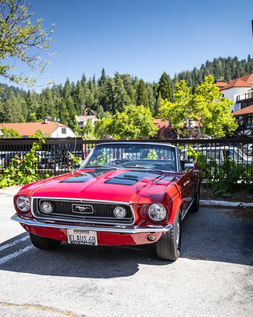 Classic Red Mustang Front View in Scenic Outdoor Setting Wallpaper
