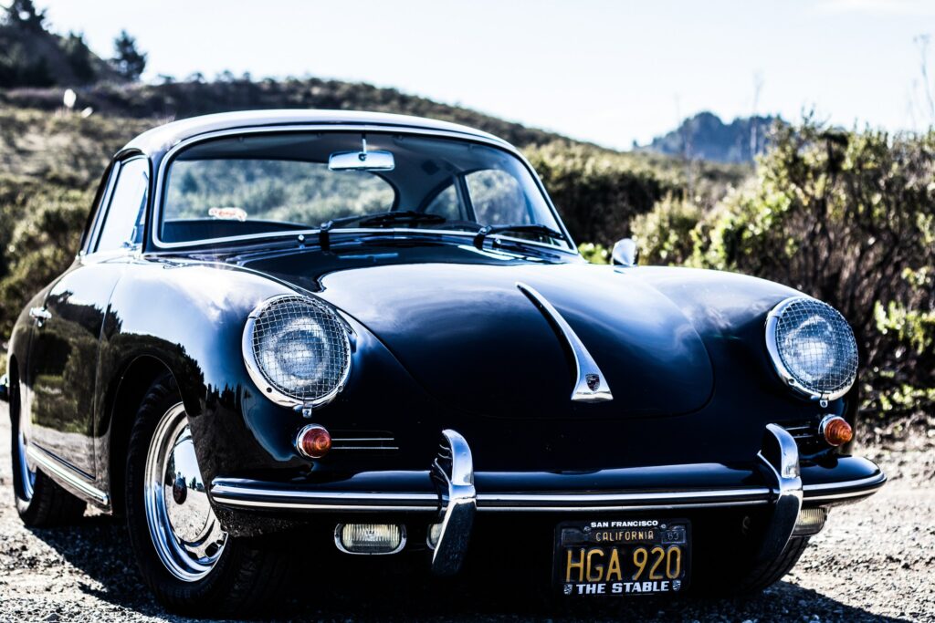 Vintage Retro Car Wallpaper: Sleek Design Against Scenic Background