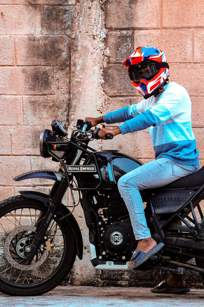 Classic Royal Enfield Himalayan Rider Wallpaper with Vibrant Helmet