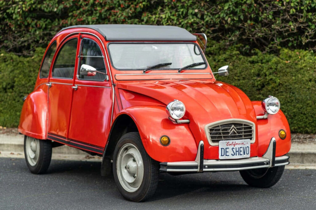 Vintage Red Citroën 2CV Wallpaper: Timeless Design with Greenery
