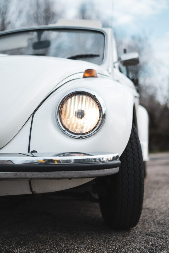 Classic White Retro Car Wallpaper: Iconic Headlight & Vintage Design