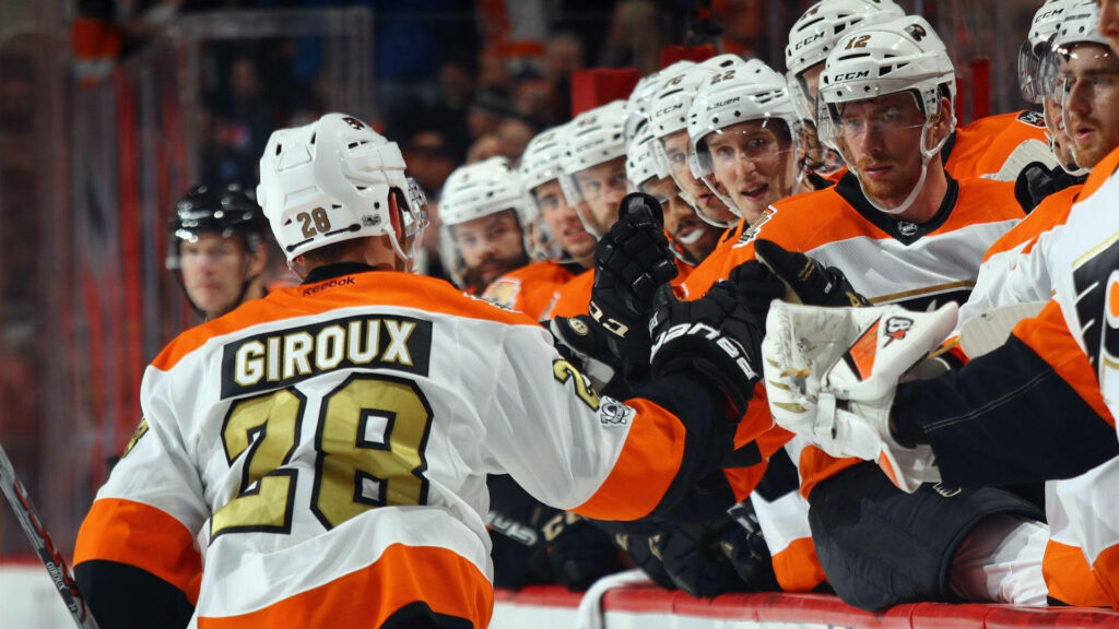 Claude Giroux celebrates with Philadelphia Flyers teammates in white and orange jerseys NHL game Wallpaper