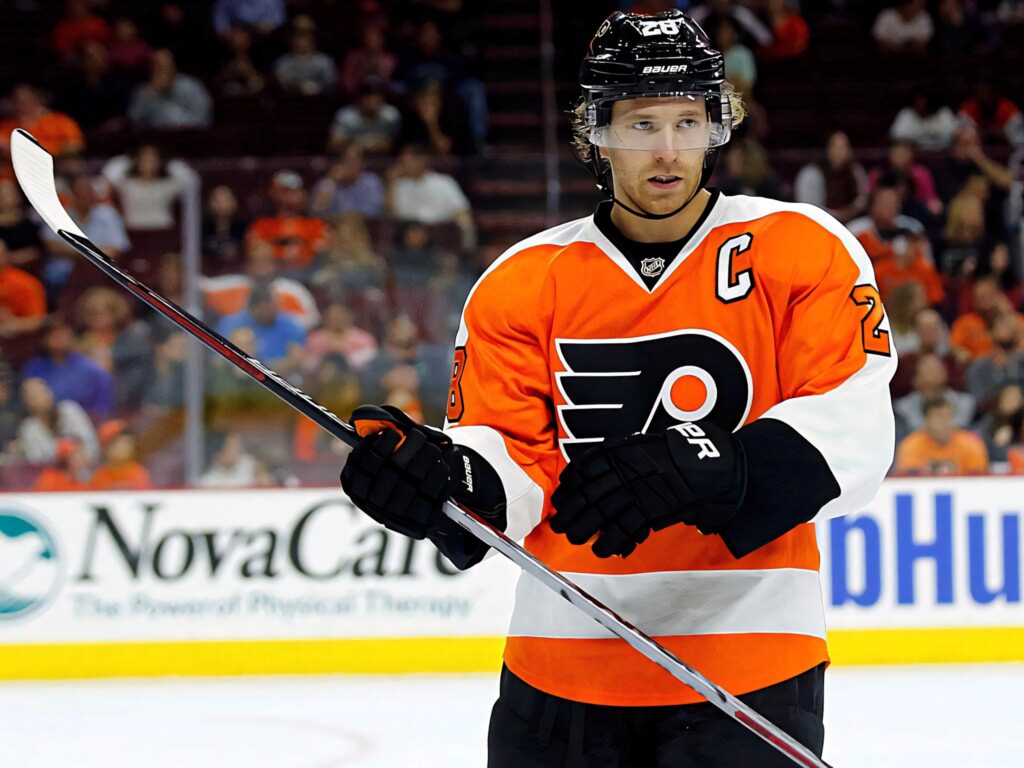 Claude Giroux Philadelphia Flyers in orange black uniform on ice with hockey stick intense pose Wallpaper