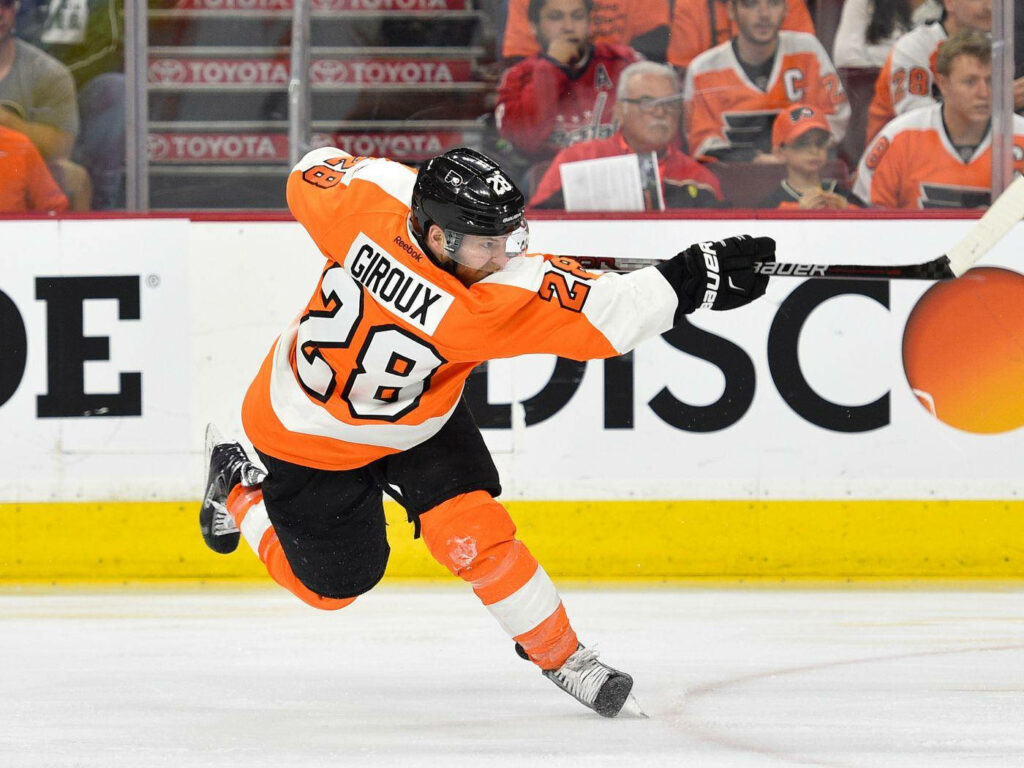 Claude Giroux Philadelphia Flyers skating powerfully in orange black uniform intense hockey action Wallpaper