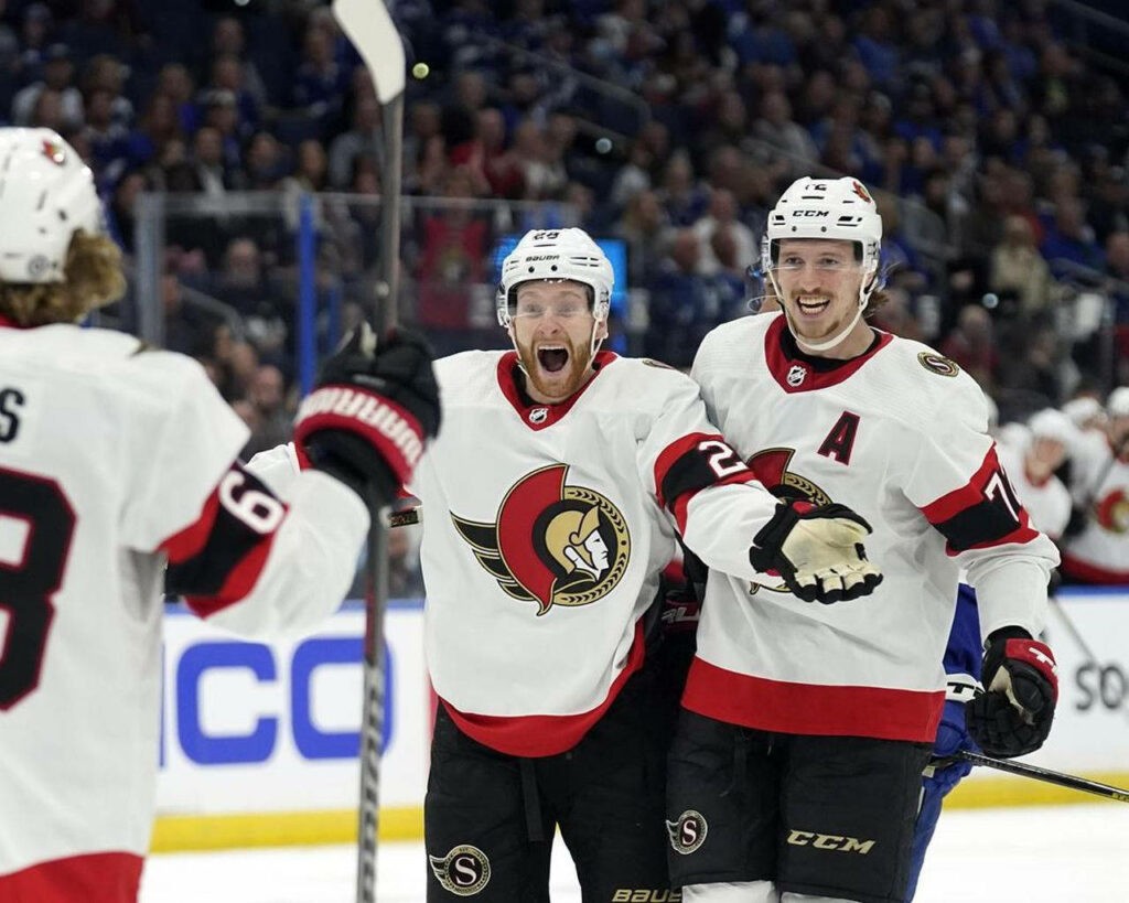 Claude Giroux and Thomas Chabot celebrating on ice in Ottawa Senators uniforms hockey action wallpaper