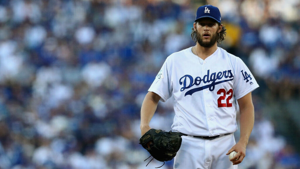 Clayton Kershaw pitching for Dodgers on mound focused during day game with blurred crowd background Wallpaper