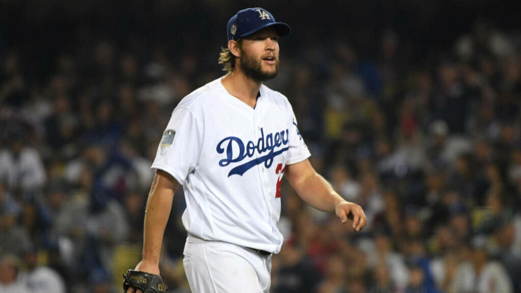 Clayton Kershaw pitching in Los Angeles Dodgers uniform under stadium lights with blurred fans Wallpaper