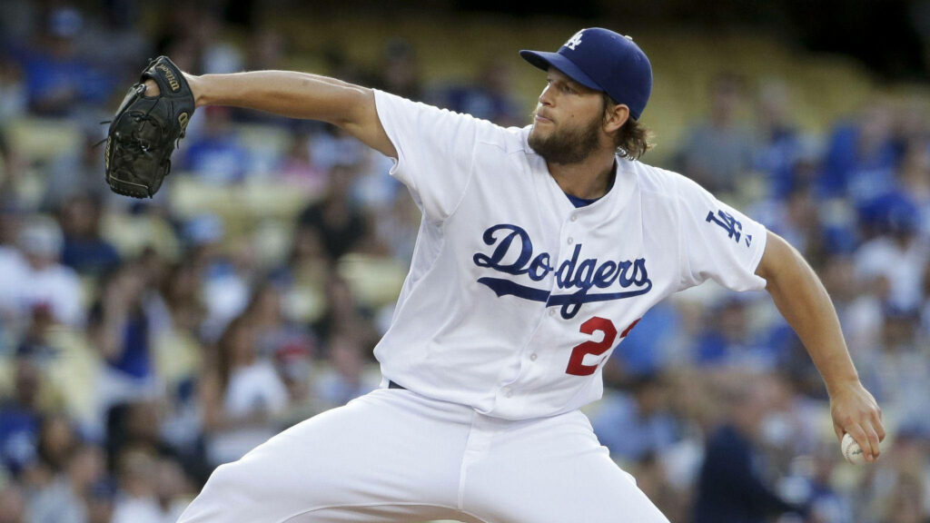 Clayton Kershaw pitching for Dodgers under stadium lights showing focus and athletic stance Wallpaper