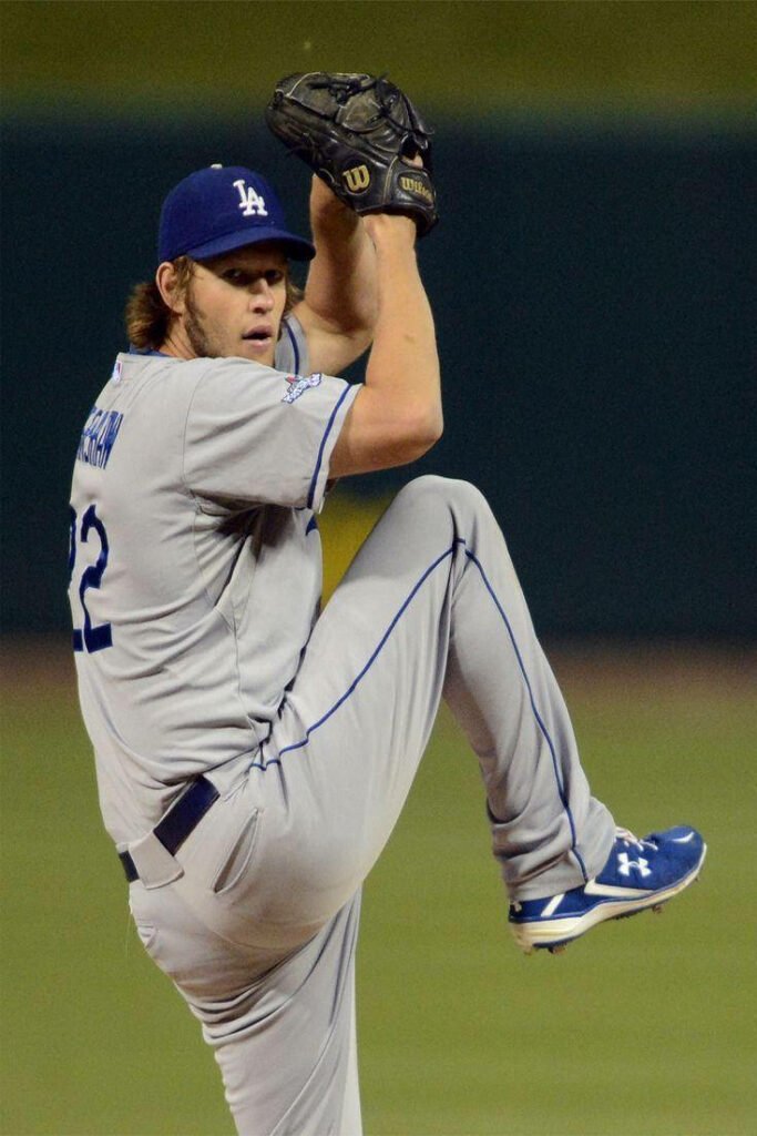 Clayton Kershaw pitching left-handed in Dodgers uniform with focused intense stadium background Wallpaper