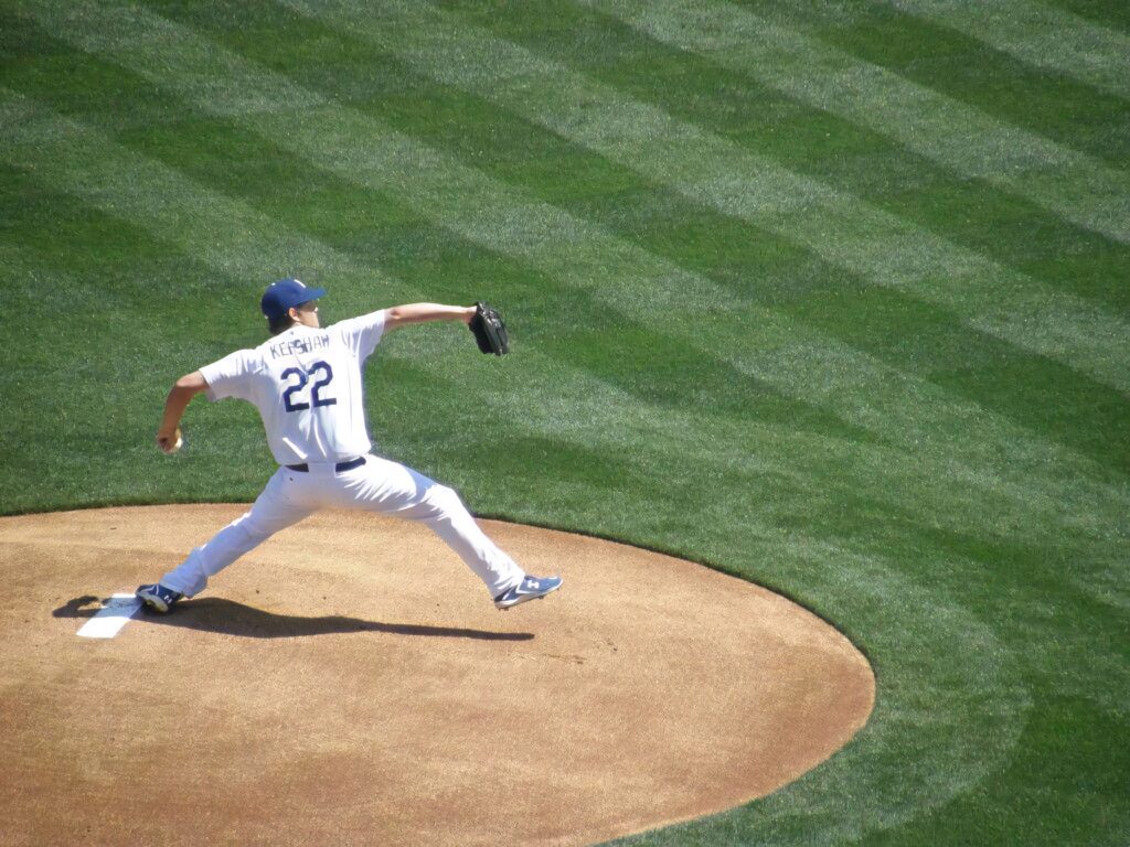 Clayton Kershaw pitching number 22 on lush green striped baseball field bird eye view wallpaper