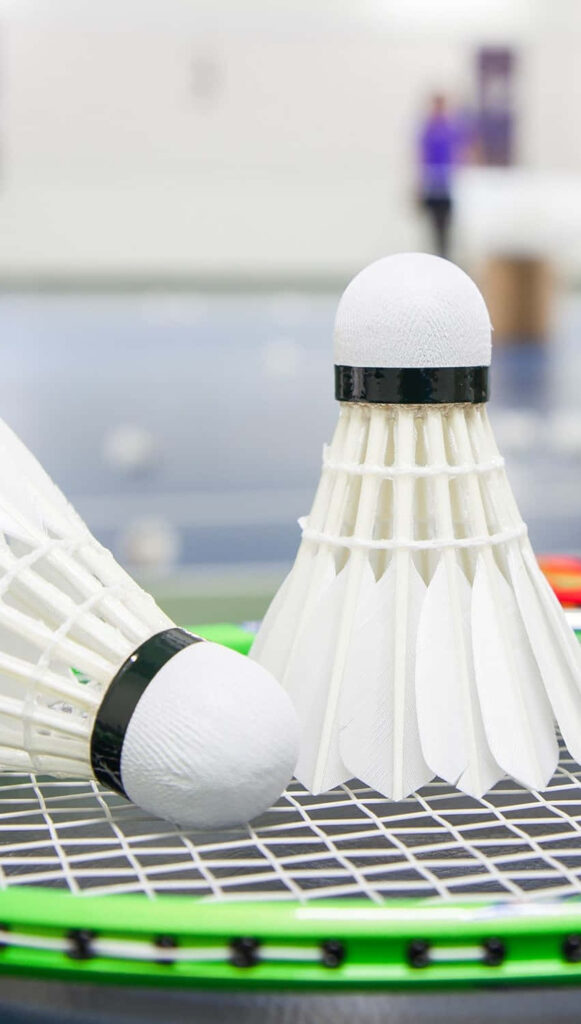 Vibrant Badminton Equipment with Pristine Shuttlecocks on a Green Racket in an Atmospheric Setting Wallpaper