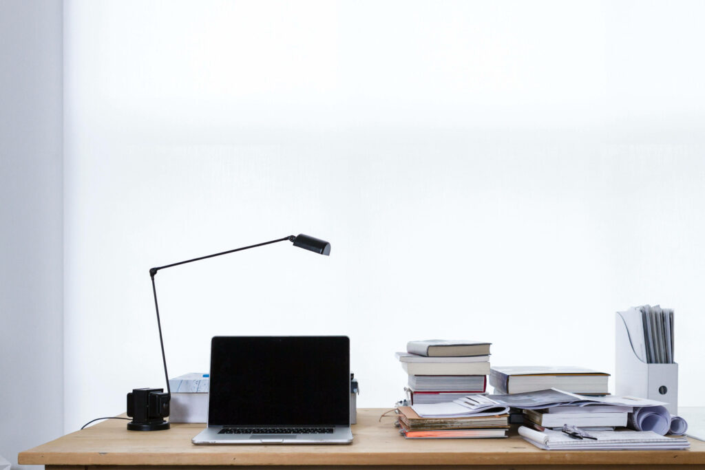 Organized Chaos: A Simple Workspace Zoom Background with Books and Files on a Wooden Table Wallpaper