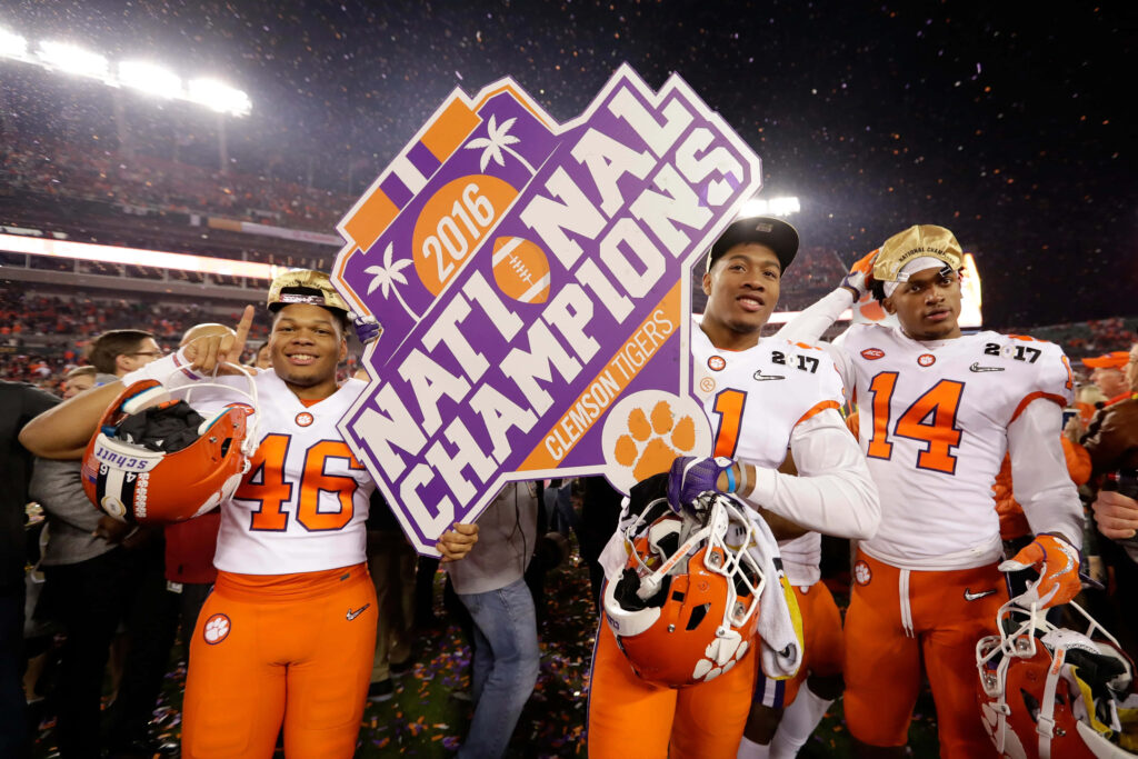 Clemson Tigers 2016 football champions celebrating with purple and gold sign and confetti Wallpaper