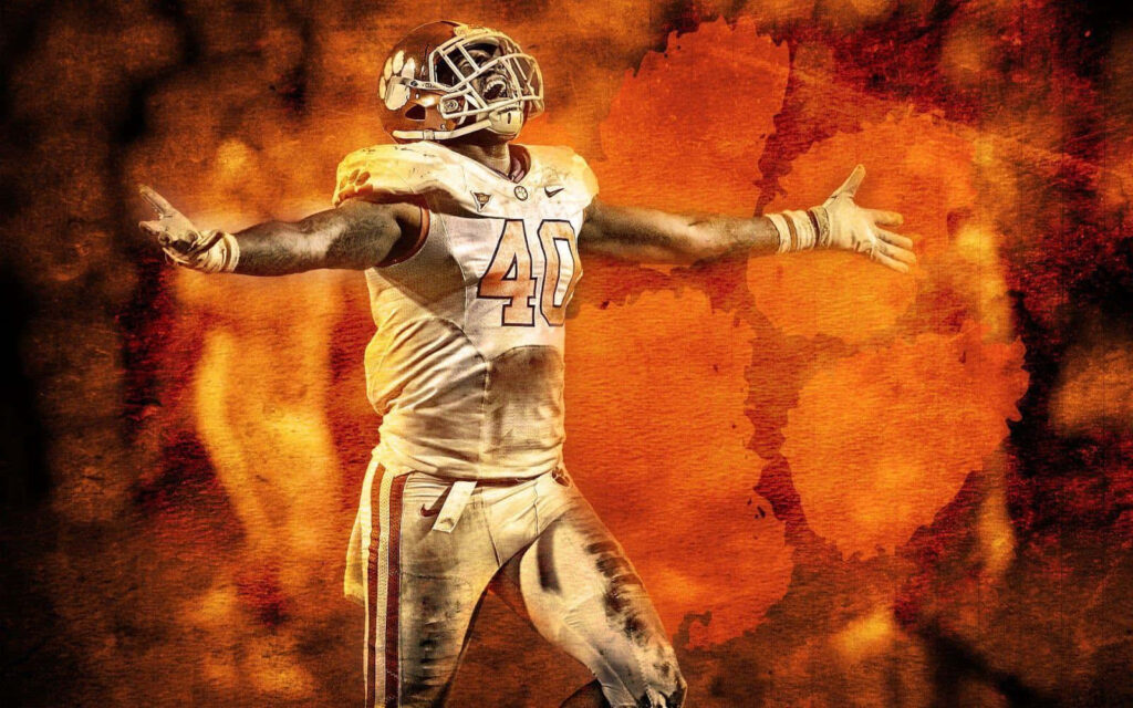 Clemson Tigers football player with arms wide on fiery orange background with paw logo Wallpaper