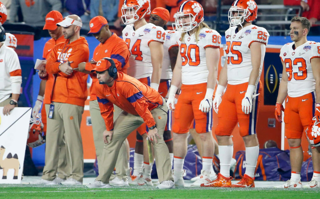 Clemson Tigers football team and coaches on sidelines in orange and white uniforms intense focus Wallpaper