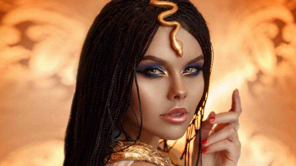Cleopatra wallpaper with golden serpent crown dramatic makeup radiant royal Egyptian queen background