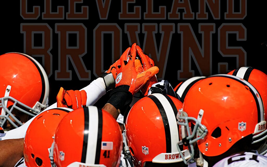 Cleveland Browns players in orange helmets unite hand stack pre game huddle teamwork wallpaper