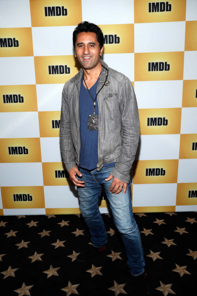 Cliff Curtis in casual outfit against bold IMDb checkered backdrop modern celebrity wallpaper