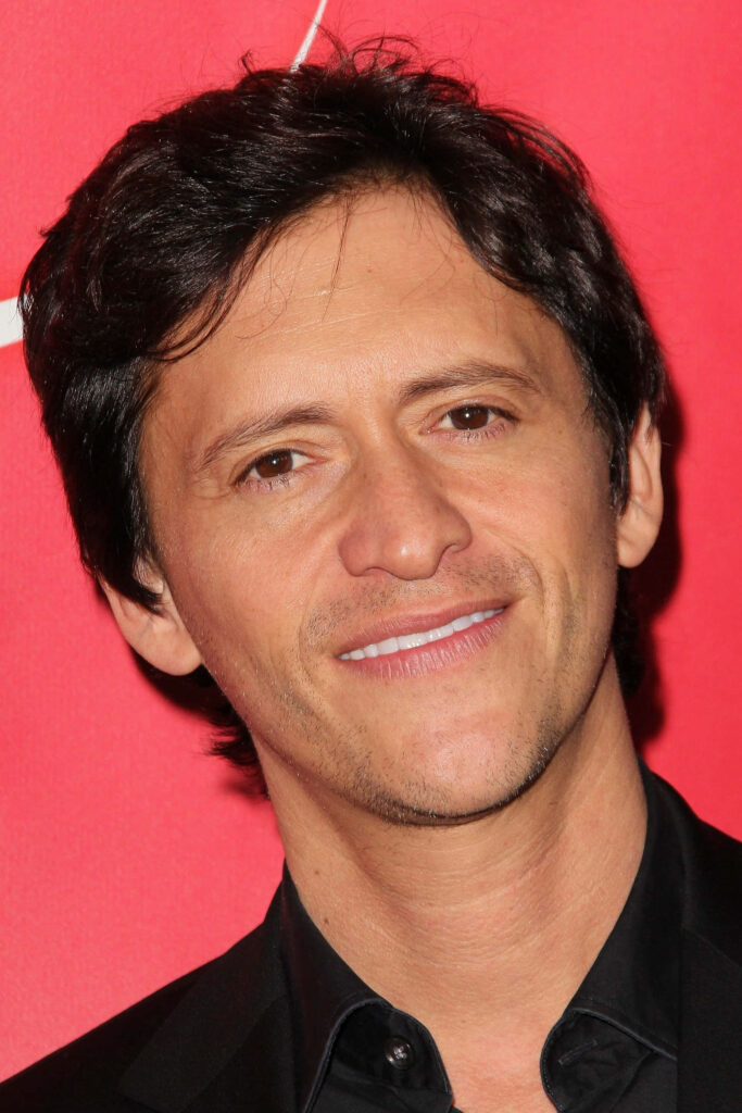 Clifton Collins Jr close-up portrait vibrant red background confident smile high resolution wallpaper