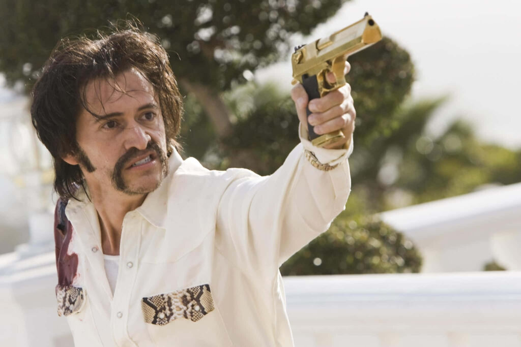 Clifton Collins Jr intense pose with gold handgun outdoors white outfit cinematic dramatic expression Wallpaper