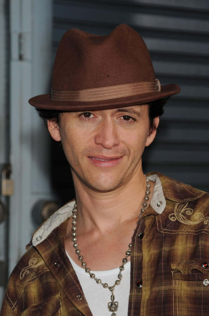 Clifton Collins Jr in brown fedora plaid shirt beaded necklace casual confident urban flair wallpaper