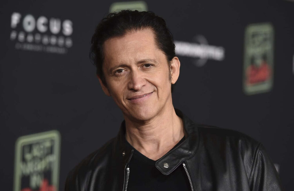 Clifton Collins Jr. in black leather jacket against dark backdrop stylish wallpaper background