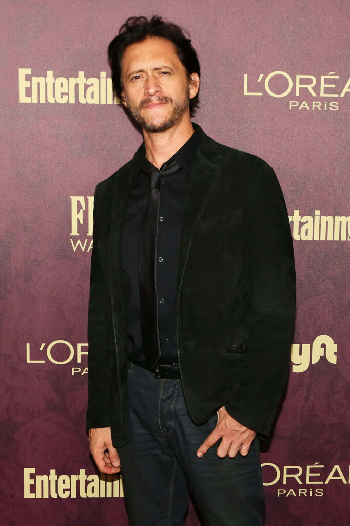 Clifton Collins Jr in dark blazer against maroon backdrop at Entertainment Weekly event wallpaper