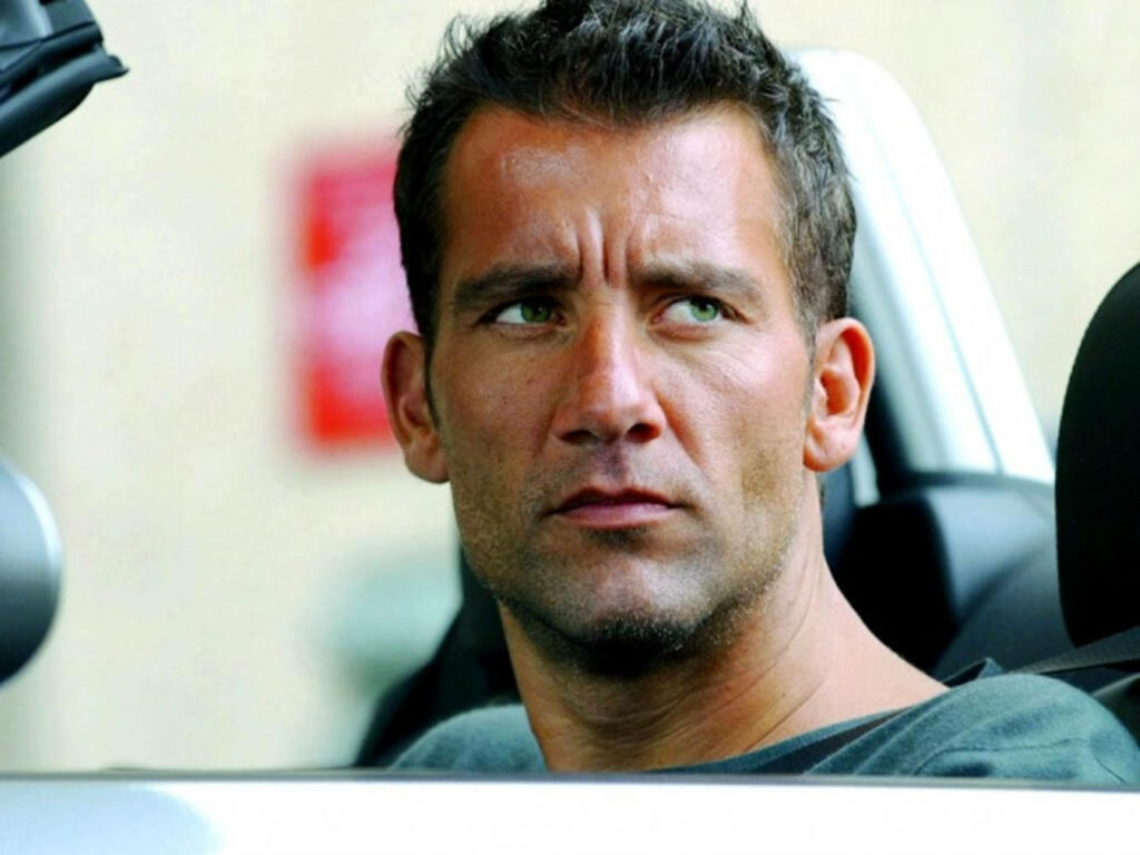 Clive Owen in convertible car focused intense cinematic natural light action scene wallpaper