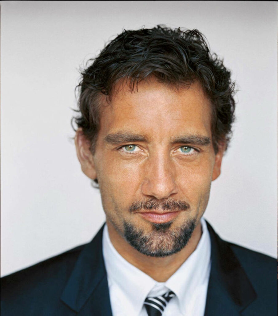 Clive Owen in sharp suit with striking blue eyes confident expression modern desktop wallpaper