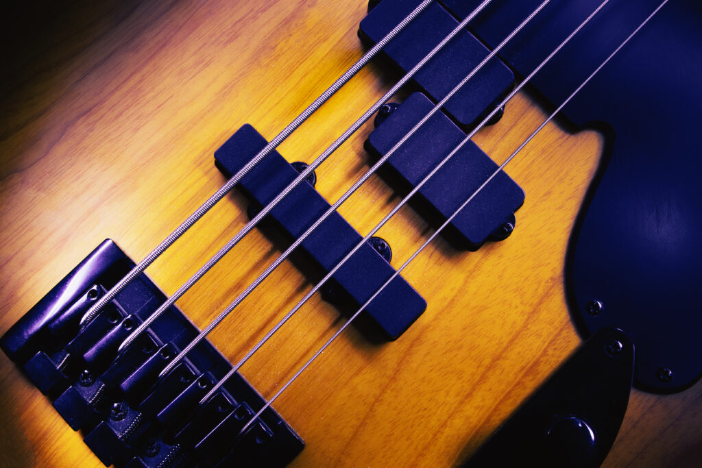 Detailed Bass Guitar Close-Up: Intricate Craftsmanship & Golden Wood Wallpaper