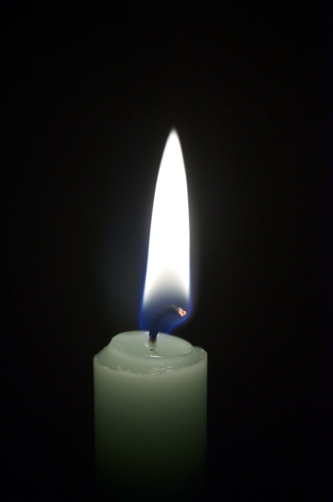 Glowing Candle Close-Up Wallpaper: Warm Flame on Dark Background