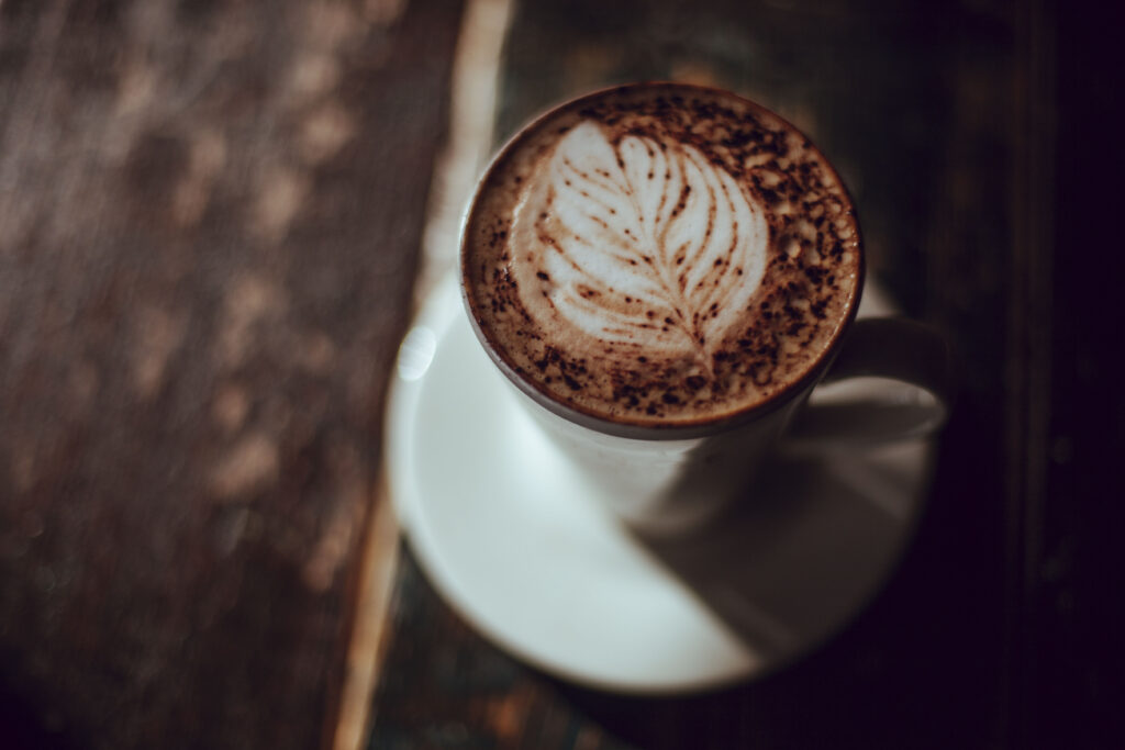Intricate Latte Art Cappuccino on Rustic Background - Wallpaper Image