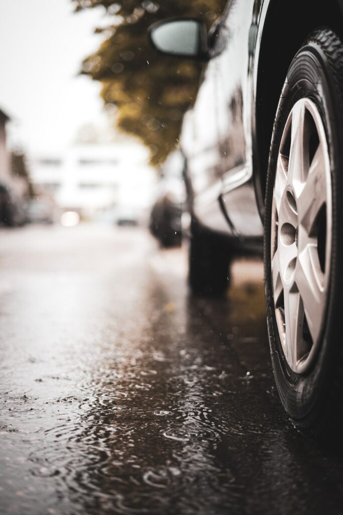 Close-Up of Car Wheel and Puddle on Rainy Day - Atmospheric Wallpaper
